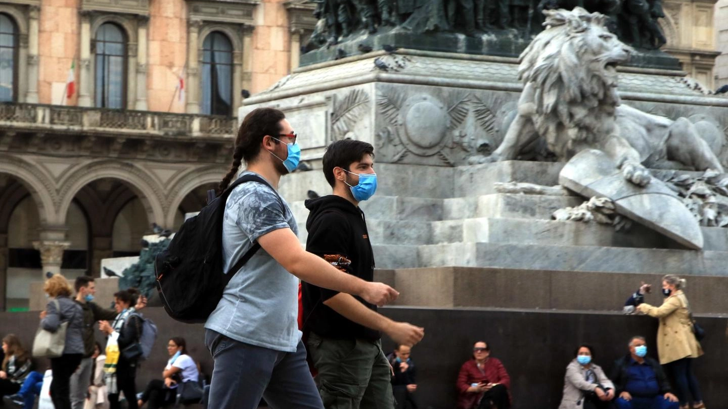 Persone camminano per le vie del centro di Milano con i volti coperti da mascherine