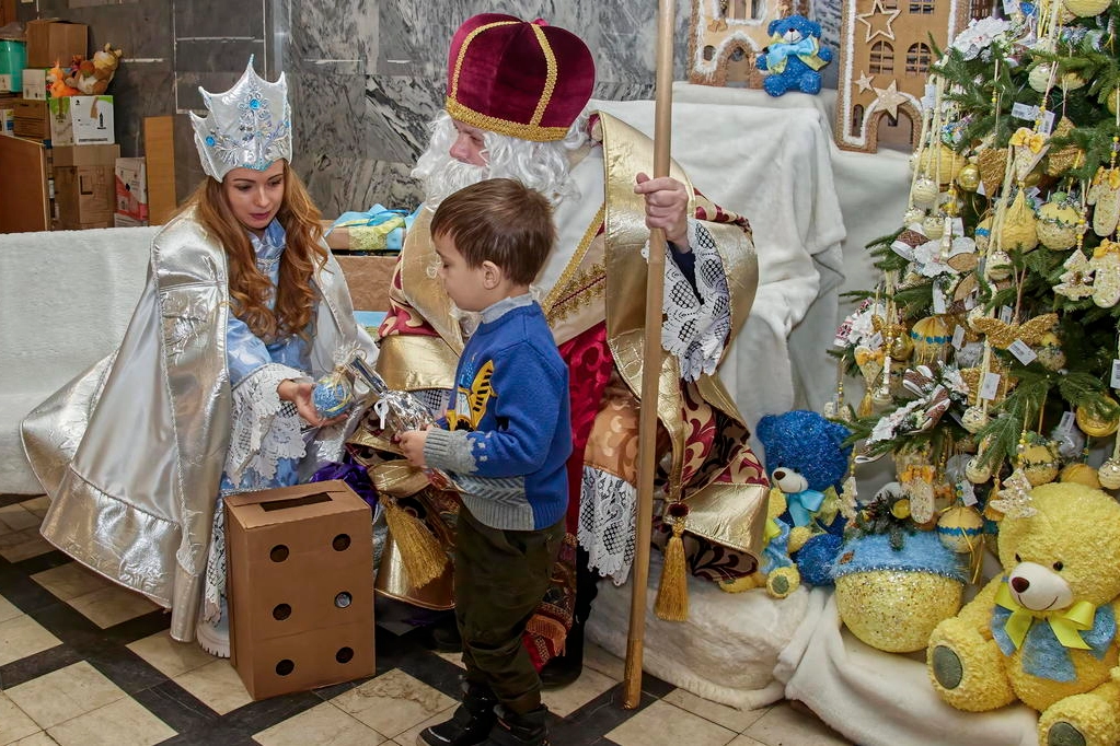 Volontari ucraini vestiti da San Nicola e Snow Maiden con un bimbo di Kharkiv