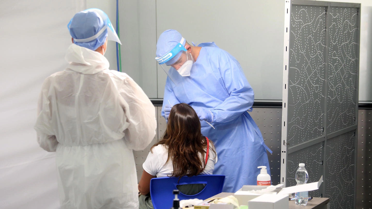 Personale medico durante l'esecuzione di un tampone a Malpensa