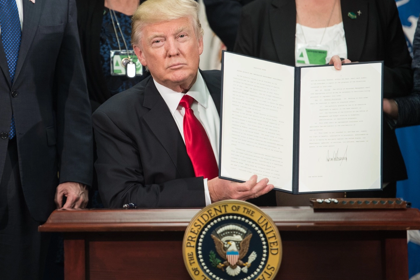 Trump mostra il decreto per la costruzione del muro col Messico (Afp)