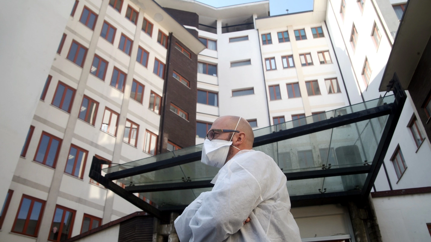 Un operatore sanitario davanti alle palazzine di una casa di riposo di Milano