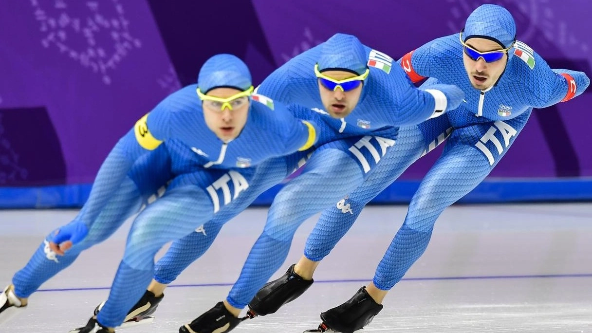 Una gara di pattinaggio di velocità con atleti azzurri olimpici sul ghiaccio