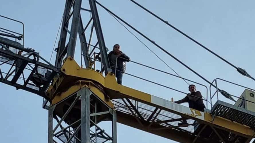 Due operai sulla gru: vogliamo i nostri soldi. Il datore di lavoro infine promette di pagare