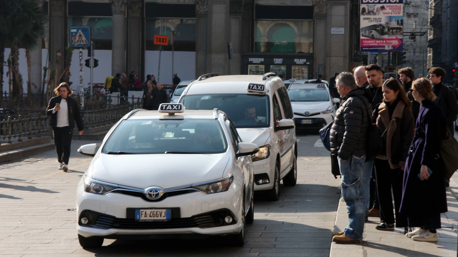 Persone in coda in attesa di un taxi libero a Milano