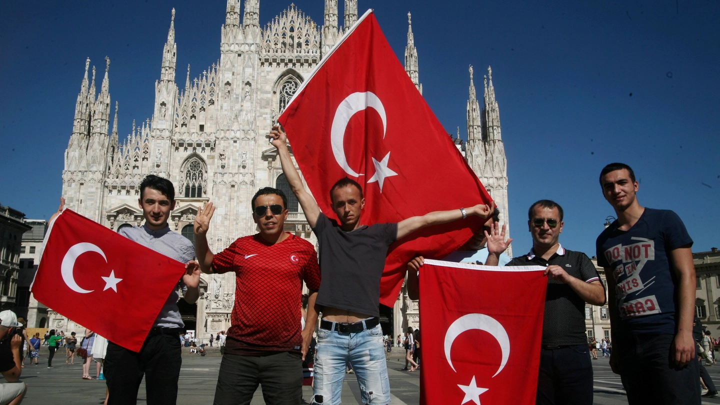 Turchi sventolano bandiere con la stella e mezzaluna davanti al Duomo