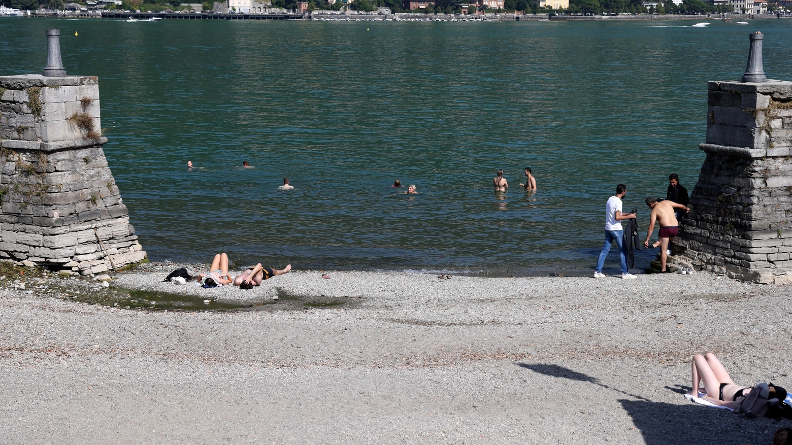 Ondata di caldo: alcune persone fanno il bagno nei pressi della darsena di villa Olmo a Como