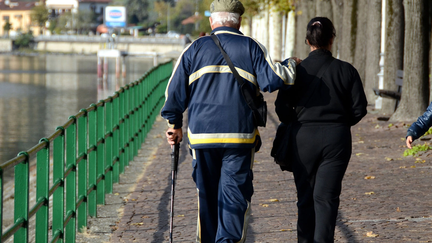 Un anziano a passeggio con la badante