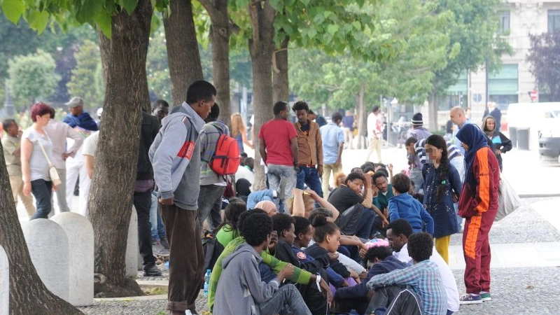 Profughi in attesa nei giardini davanti alla Stazione Centrale di Milano