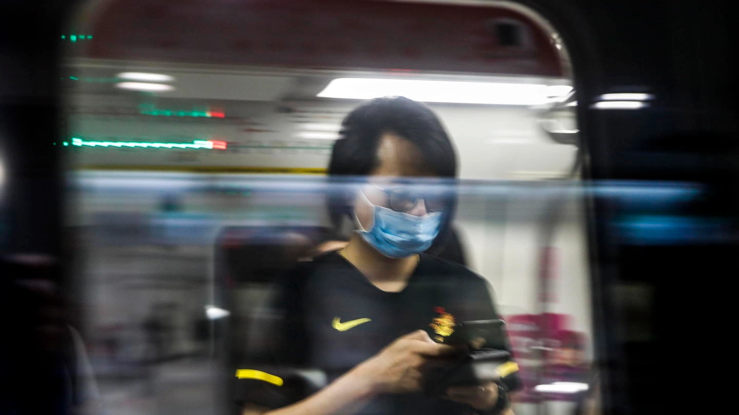 Coronavirus, viaggiatori con la mascherina a Singapore (Ansa)
