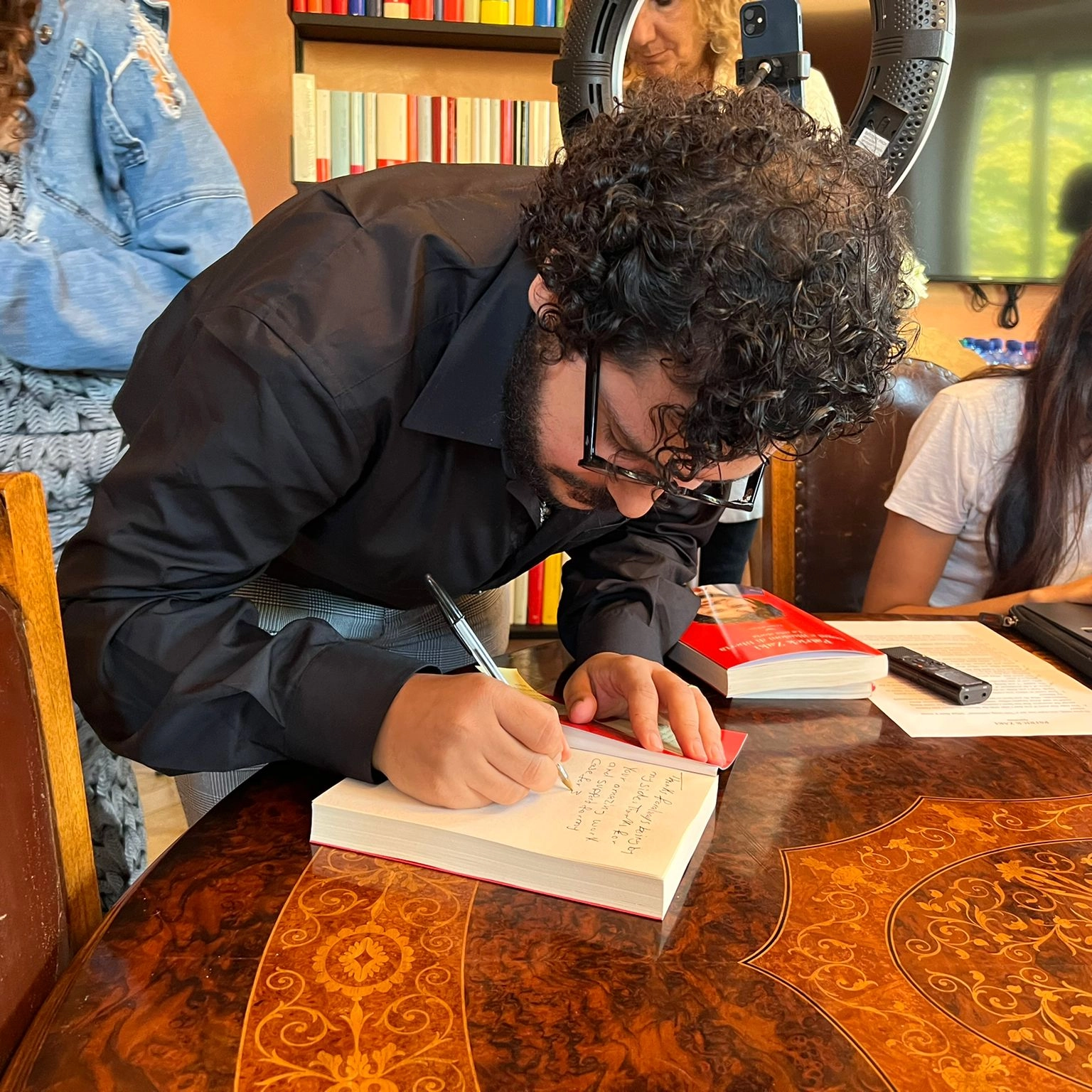 Patrick Zaki firma le copie del suo libro nella sede della Nave di Teseo a Milano