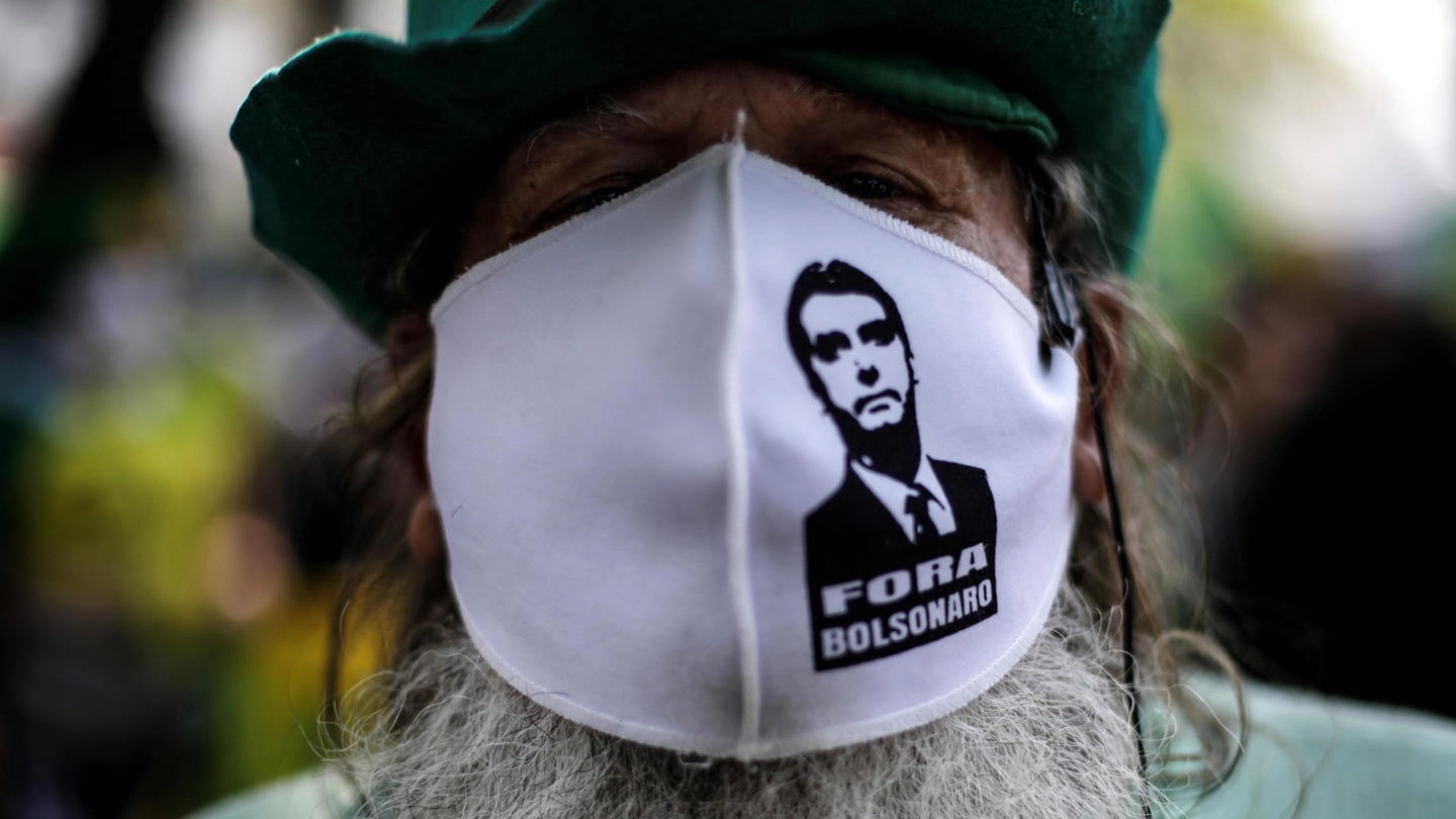 Un oppositore di Bolsonaro con la mascherina che lo ritrae