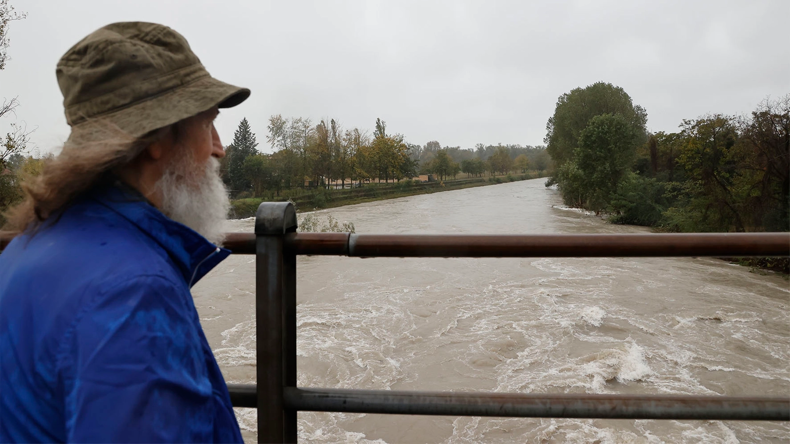 Un cassanese osserva l'Adda gonfio d'acqua