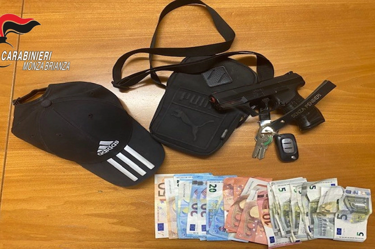 L'arma e i soldi sequestrati ai due rapinatori