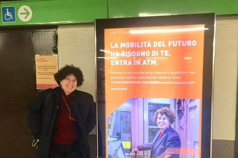 Elena Lenti posa affianco al cartellone dell'Atma sulle selezioni di nuovi macchinisti