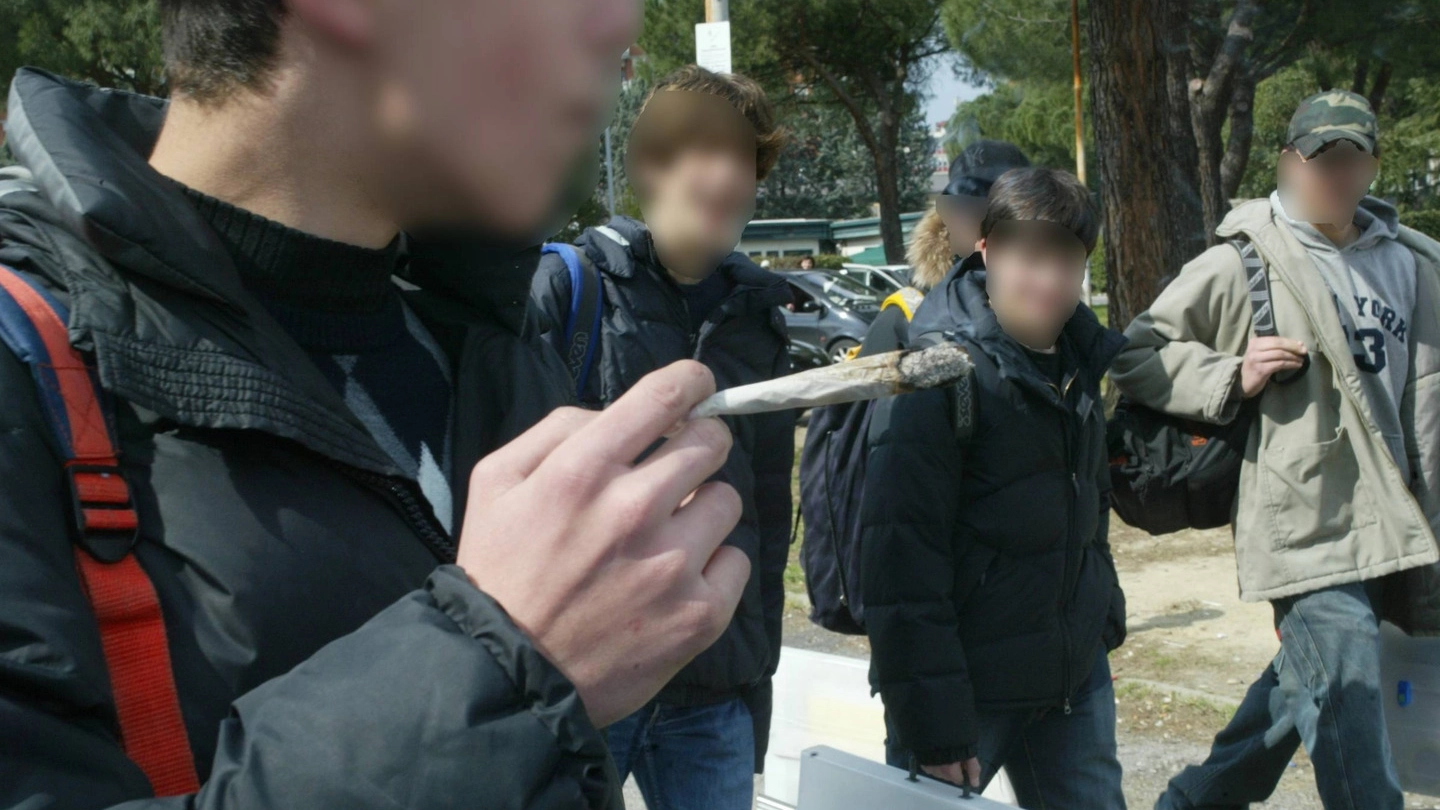 Un ragazzo fuma uno spinello all’uscita di scuola