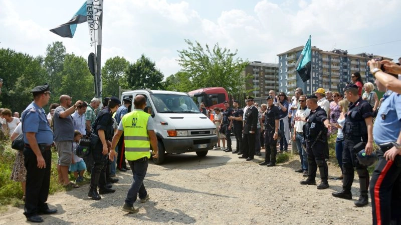 Manifestanti, carabinieri e al centro un furgone degli operai per il cantiere della Rho-Monza