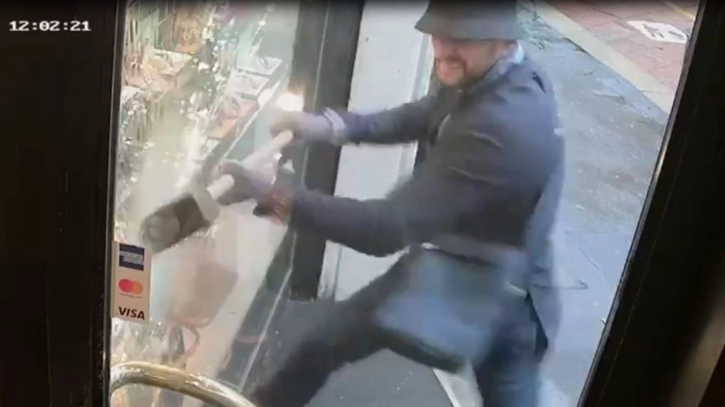 Nel frame del video delle telecamere il rapinatore colpisce la vetrina con una mazza 