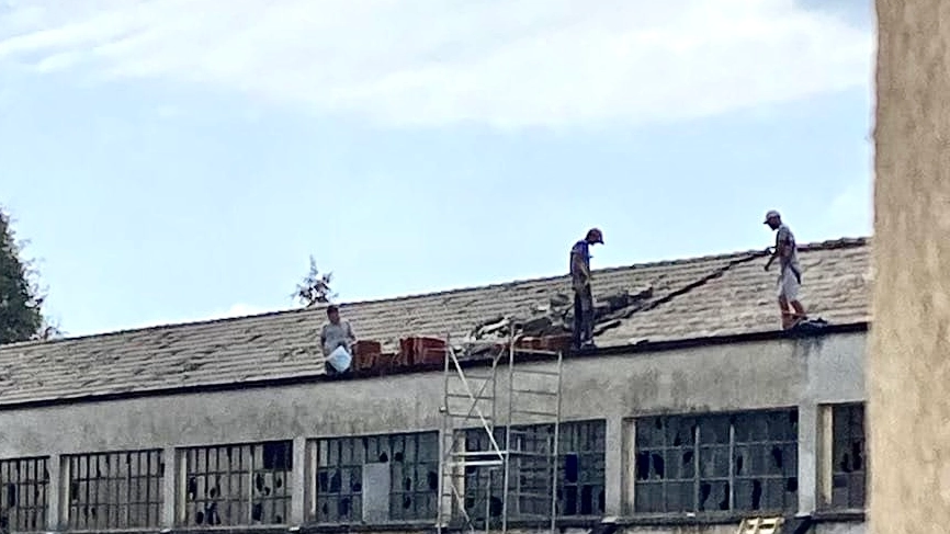 Operai al lavoro sul tetto senza protezioni