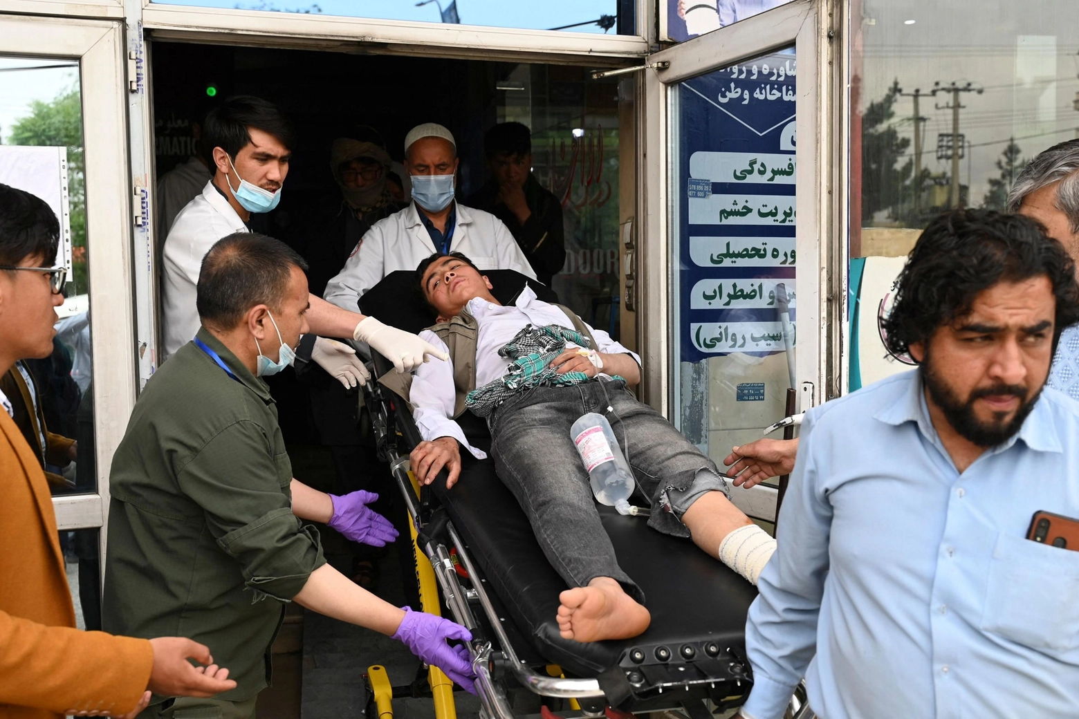 Medici con un giovane ferito in un ospedale a Kabul il 19 aprile (ANSA)