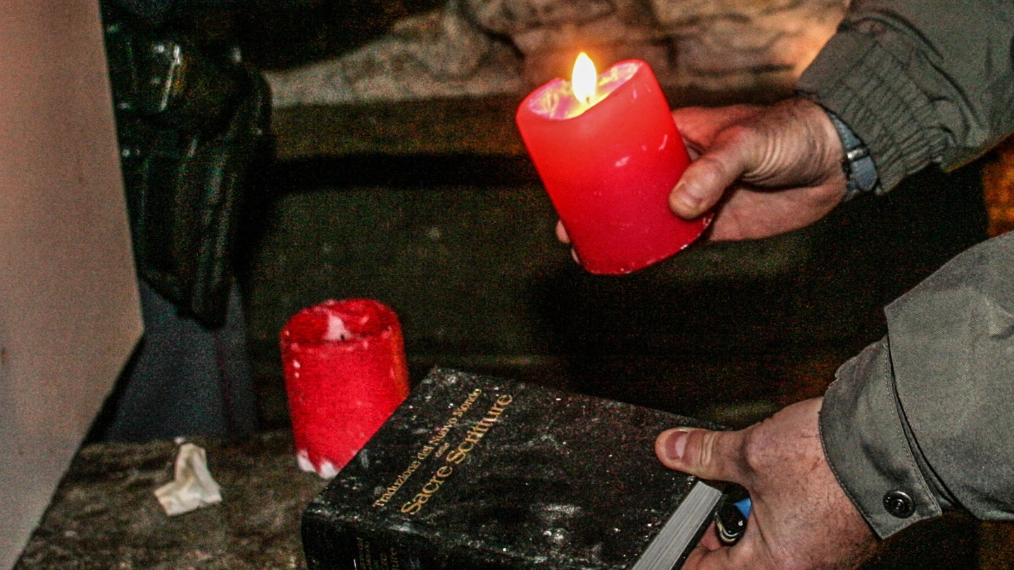 Una bibbia e delle candele utilizzate per un rito esoterico