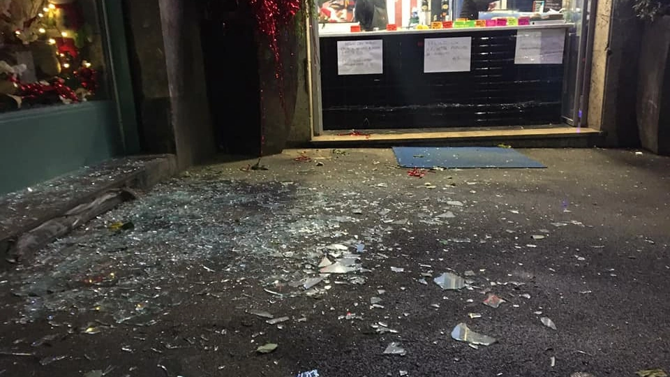 La vetrina infranta dalla bomba carta lanciata nel locale Cicciopizza (foto Facebook)