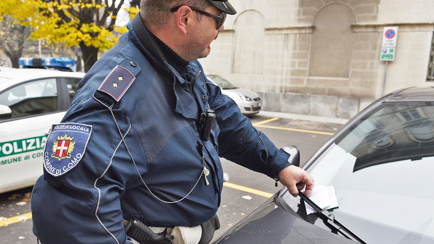 Un agente della polizia locale di Como mentre posiziona un verbale