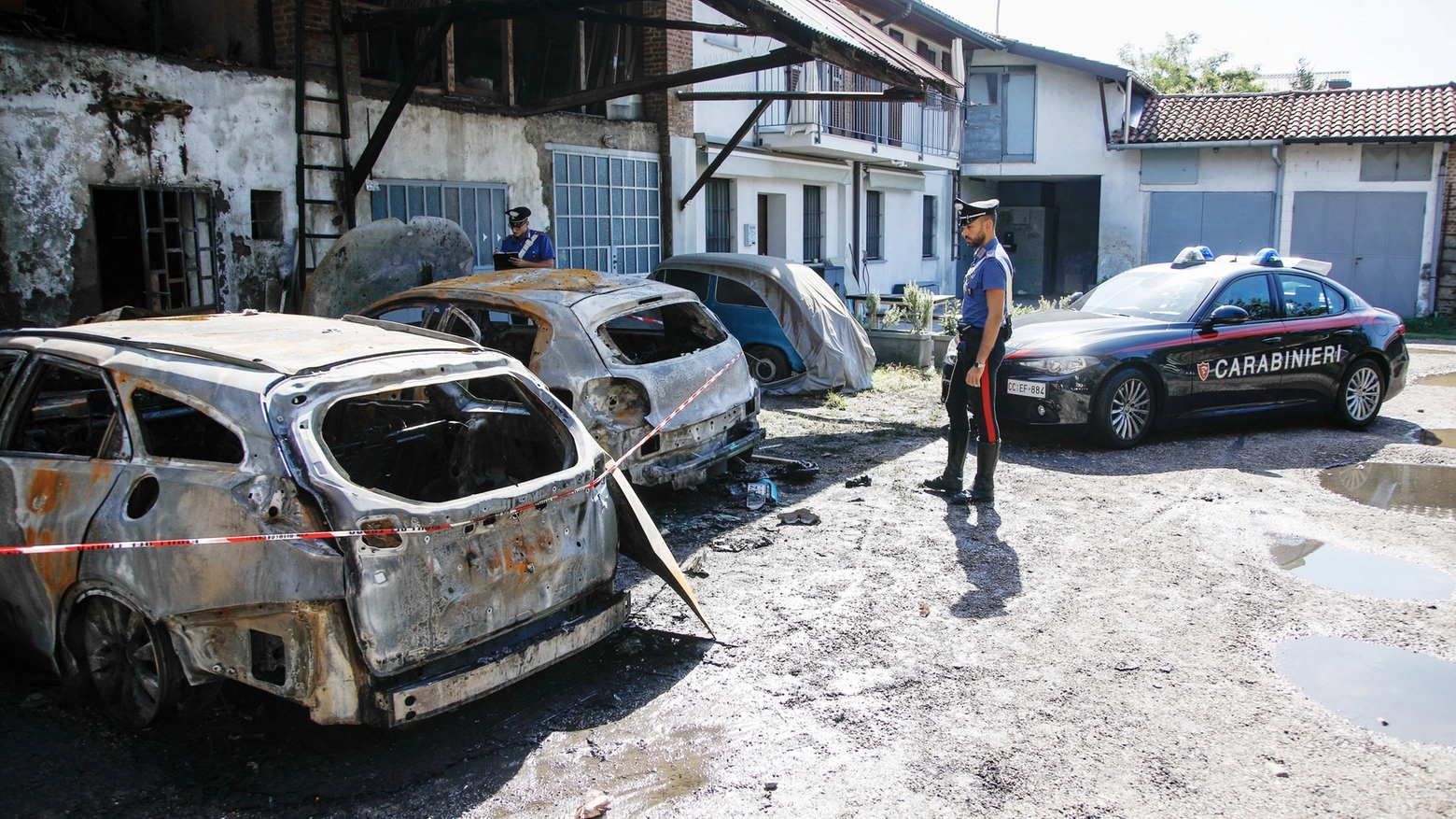 I carabinieri e le auto incendiate in un cortile di via Cristoforo Colombo a Cornaredo
