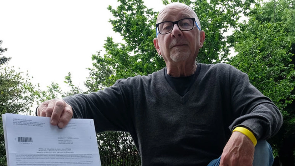 Claudio Trenta, 72, anni davanti alla buca che ha chiuso, mostra il maxi-verbale
