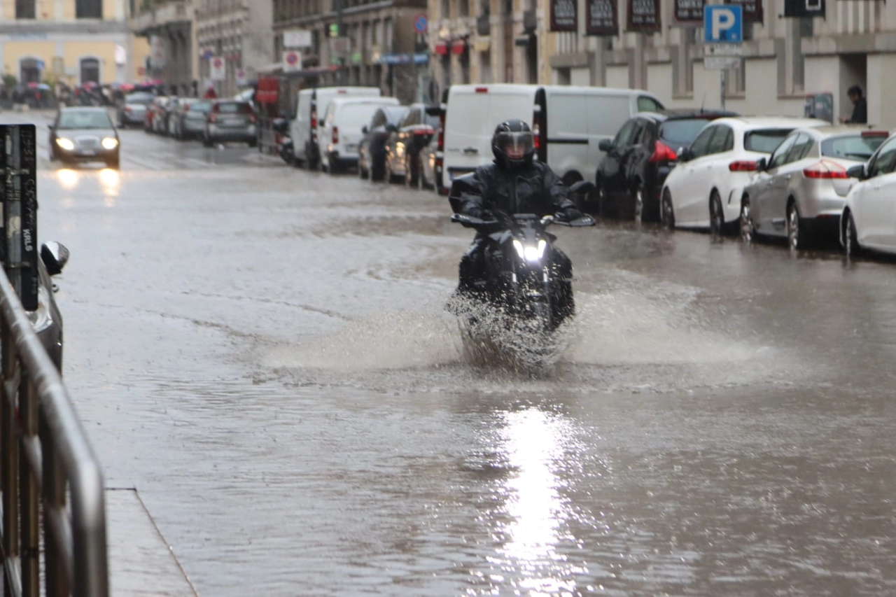 Uno scooter attraversa una strada allagata (Salmoirago)