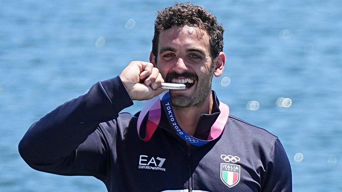 Manfredi Rizza morde la medaglia d'argento sul podio olimpico