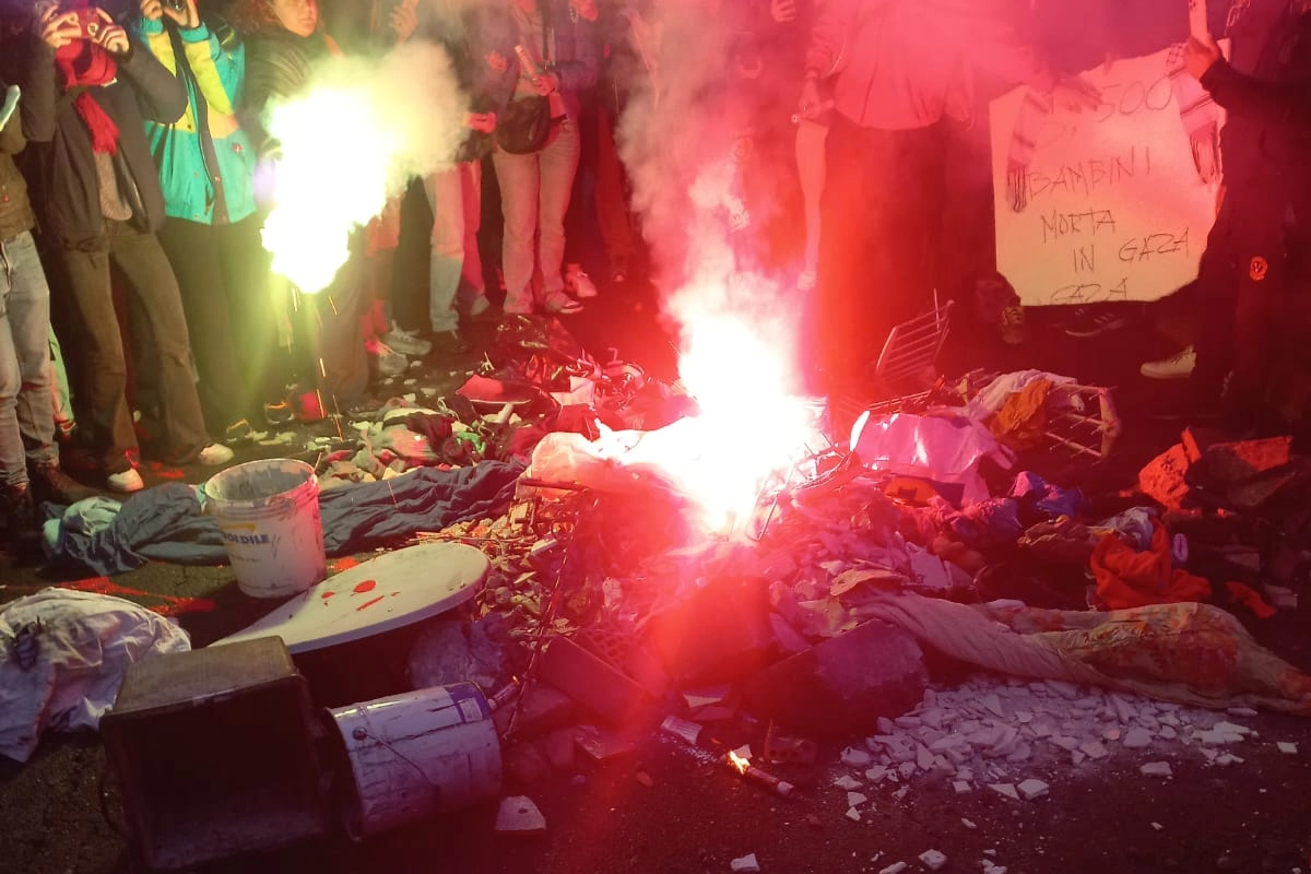 I manifestanti simulano le macerie di Gaza con mattoni e vestiti in fiamme