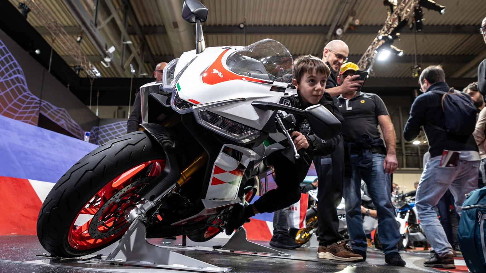 Un giovanissimo appassionato allo stand Aprilia (Courtesy EICMA) Un giovanissimo appassionato allo stand Aprilia (Courtesy EICMA)