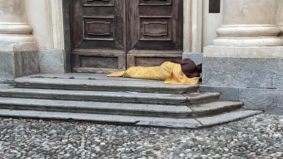 L'uomo che dorme sul sagrato della chiesa in centro L'uomo che dorme sul sagrato della chiesa in centro