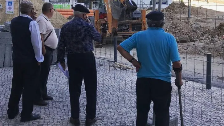 Un gruppo di anziani davanti a un cantiere