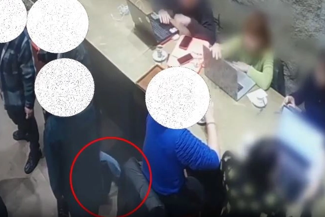 Nel frame del video si nota il movimento col piede per avvicinare la borsa da rubare
