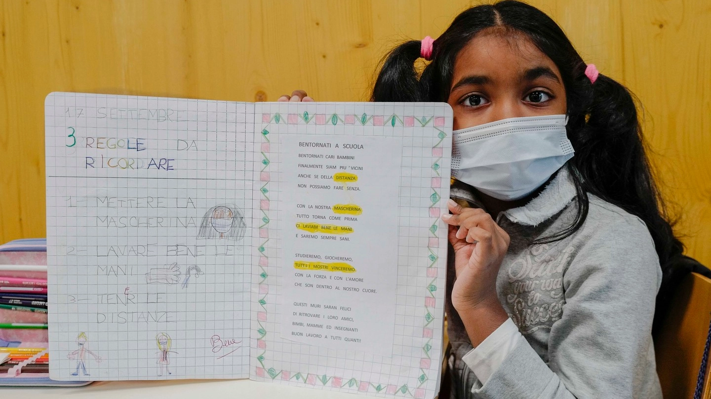 Una alunna mostra il “vademecum“ per il rientro a scuola in sicurezza durante la pandemia
