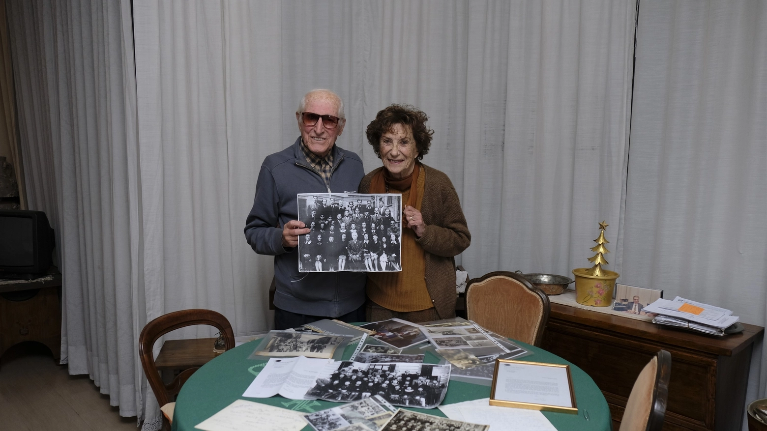 Armando Pasini e Liliana Sansoni mostrano la foto di classe. Sul tavolo scatti di Veronesi