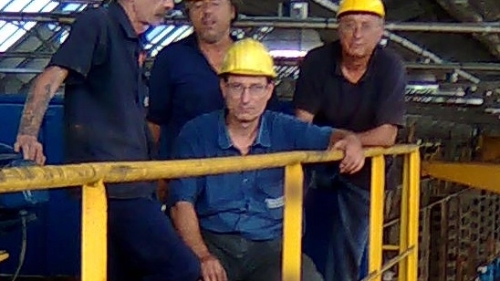 Da sinistra, Massimo Merlo e gli altri tre operai  sul carroponte a dieci metri di altezza all’interno della fabbrica