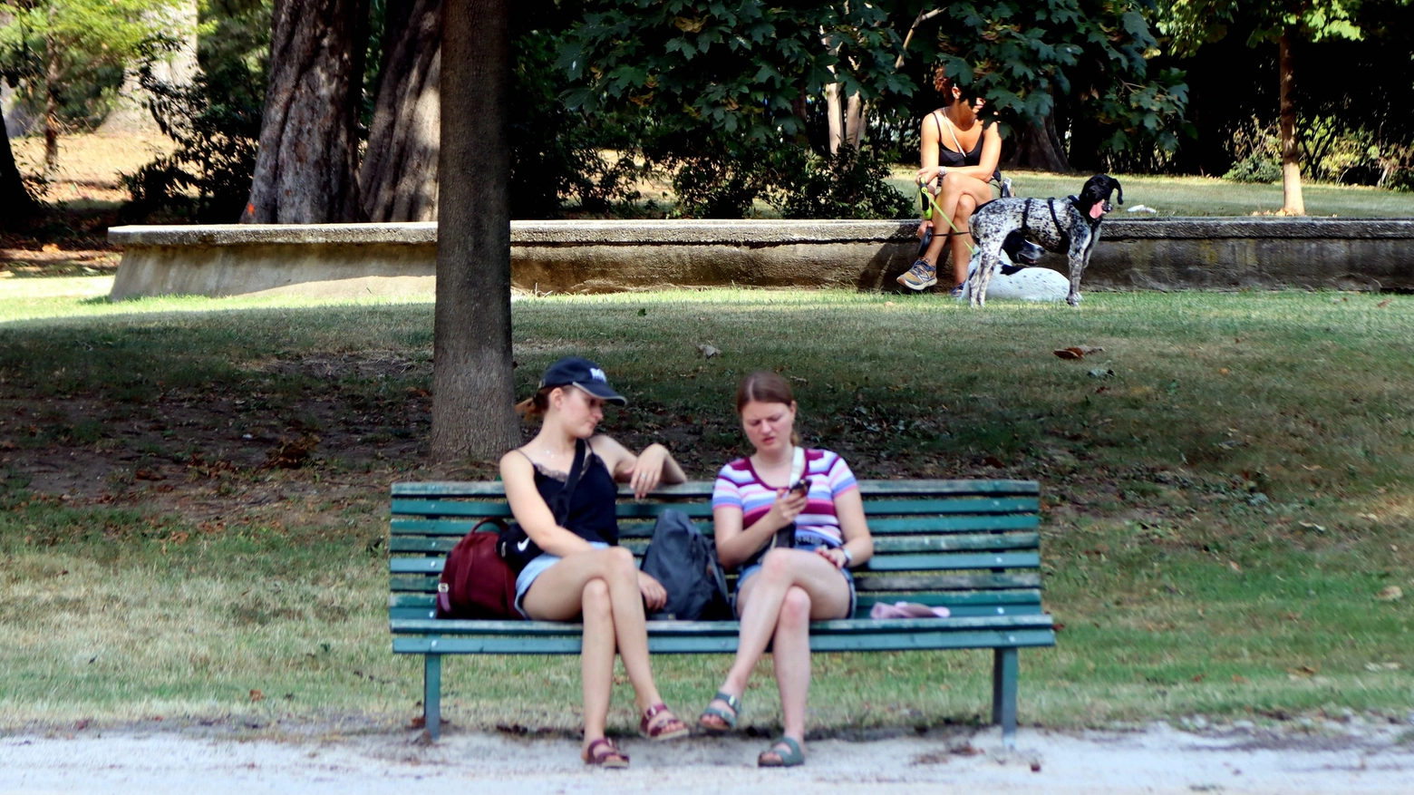 Due turiste si godono l'ombra su una panchina del Parco Sempione