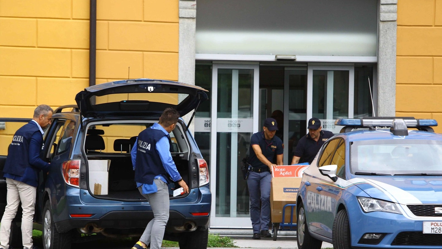Gli investigatori della Mobile portano via materiale dagli uffici della Secam (Anp)