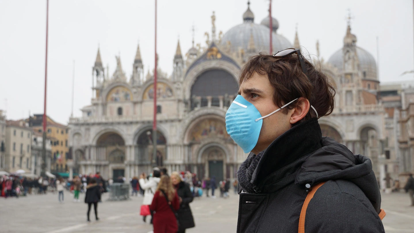 Un turisti con la mascherina a Venezia (Ansa)