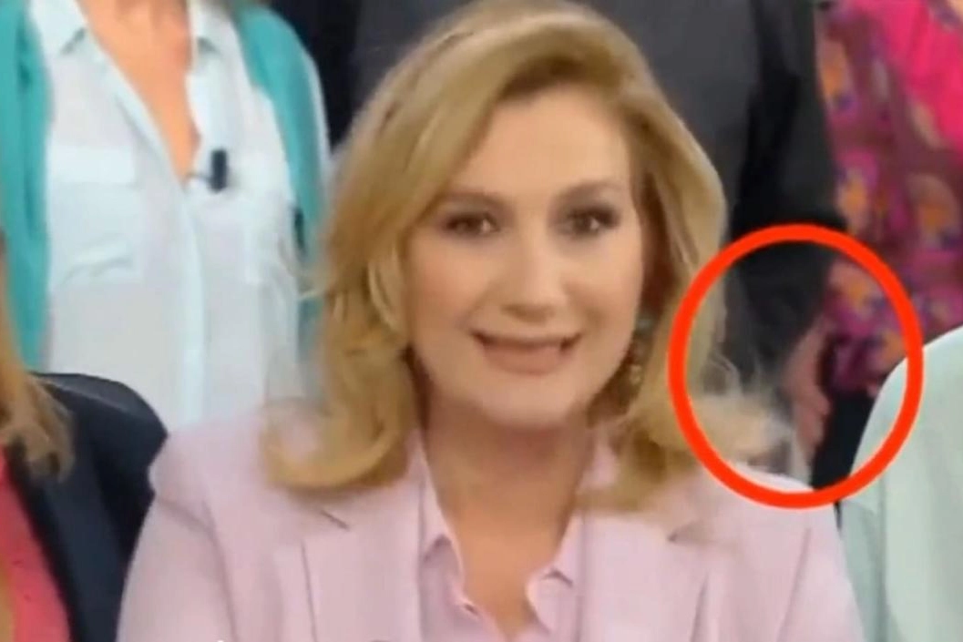 Memo Remigi mentre fa scivolare la mano sul fondoschiena di Jessica Morlacchi