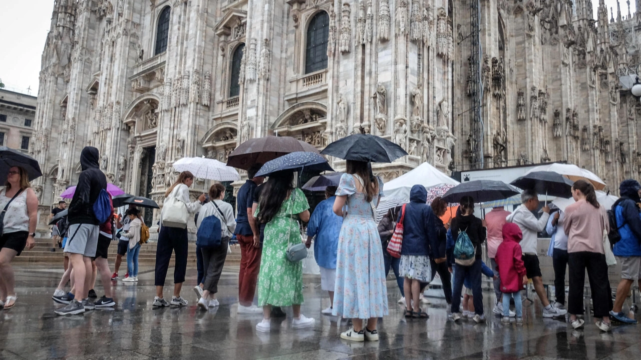 Pioggia in piazza del Duomo a Milano (Ansa)