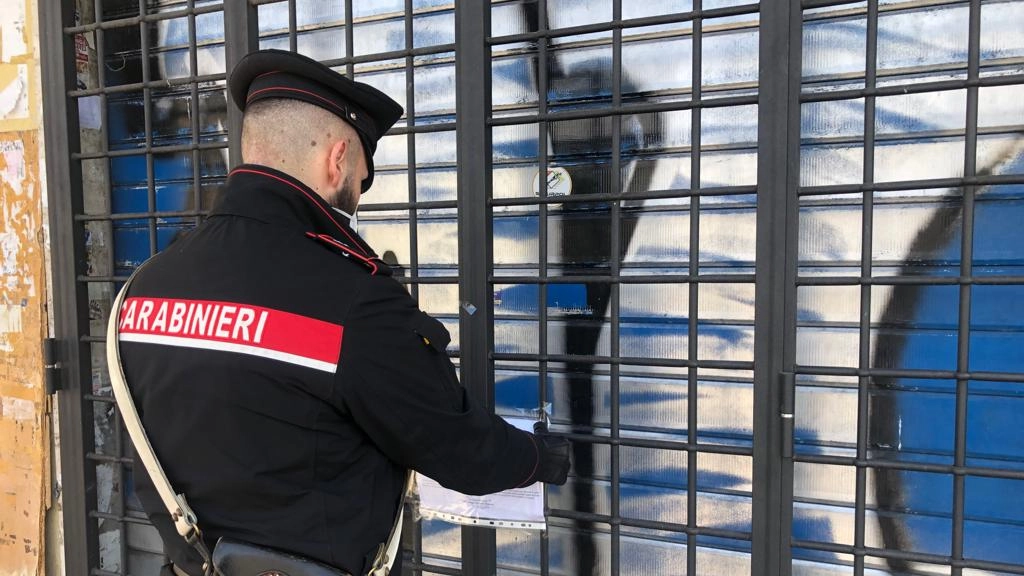 Carabiniere appone i sigilli di chiusura di un locale