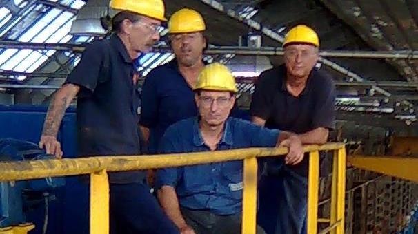 Da sinistra Massimo Merlo e gli altri operai sul carroponte della Innse (NewPress)