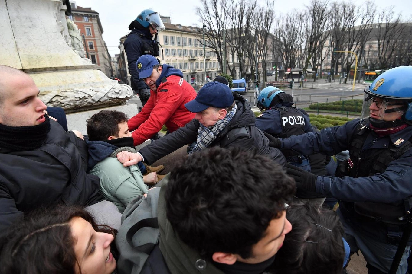 La polizia sgombera alcuni studenti saliti sul monumento di piazza Cairoli a Milano (Ansa)