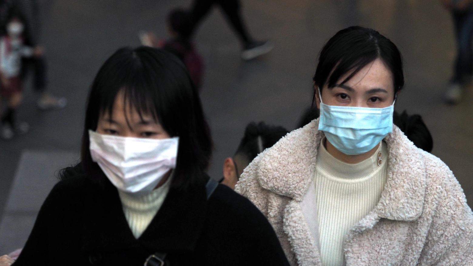 Cina, passanti in strada indossano la mascherina 