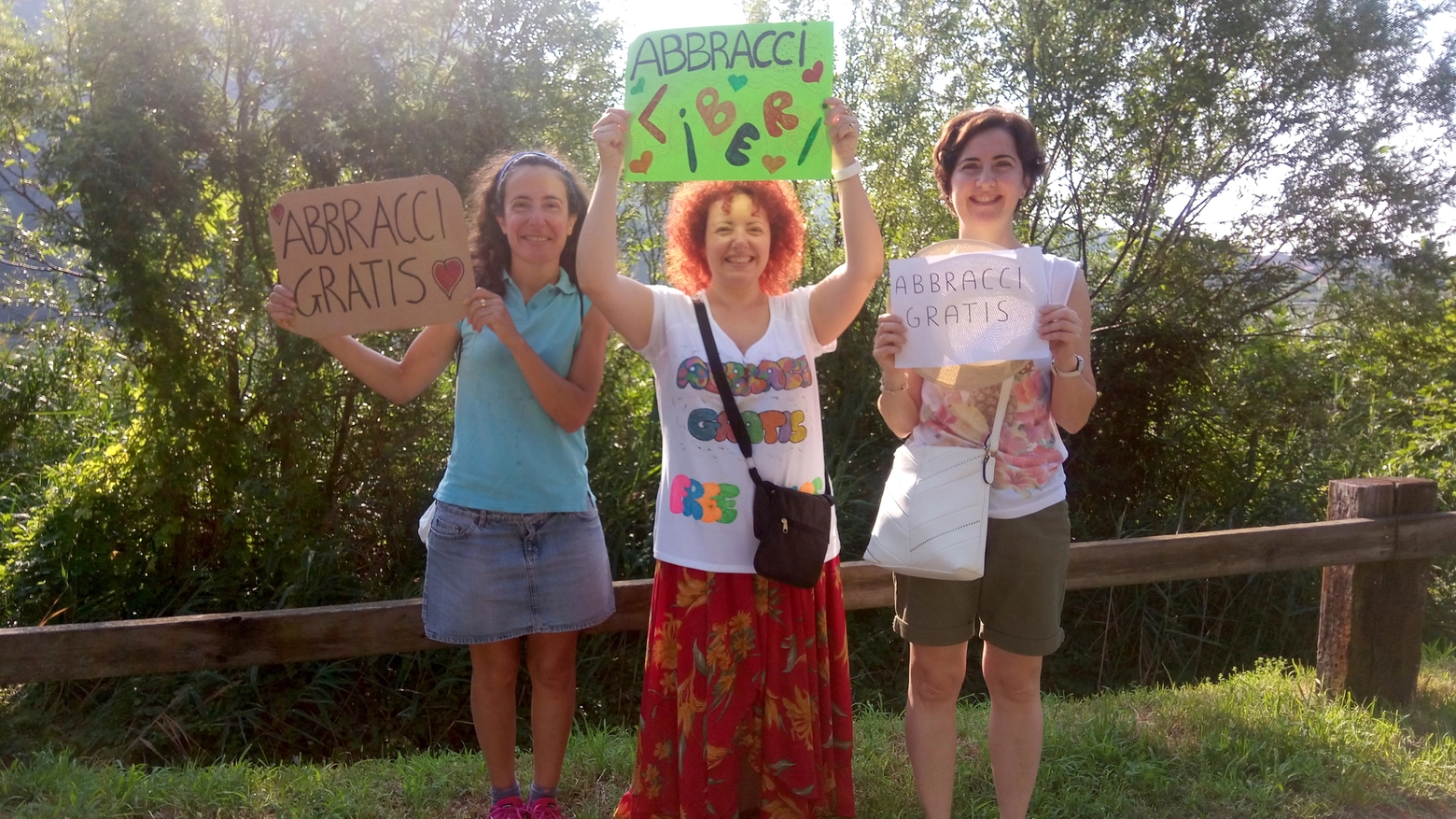 Fiammetta Mandelli, Laura Aliverti, linda Gennuso mostrano i cartelli per gli abbracci gra