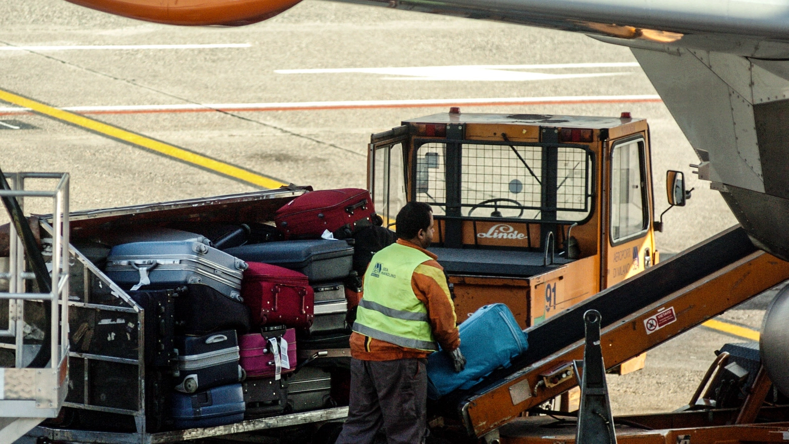 Addetti allo scarico dei bagagli a Malpensa (Foto d'archivio)