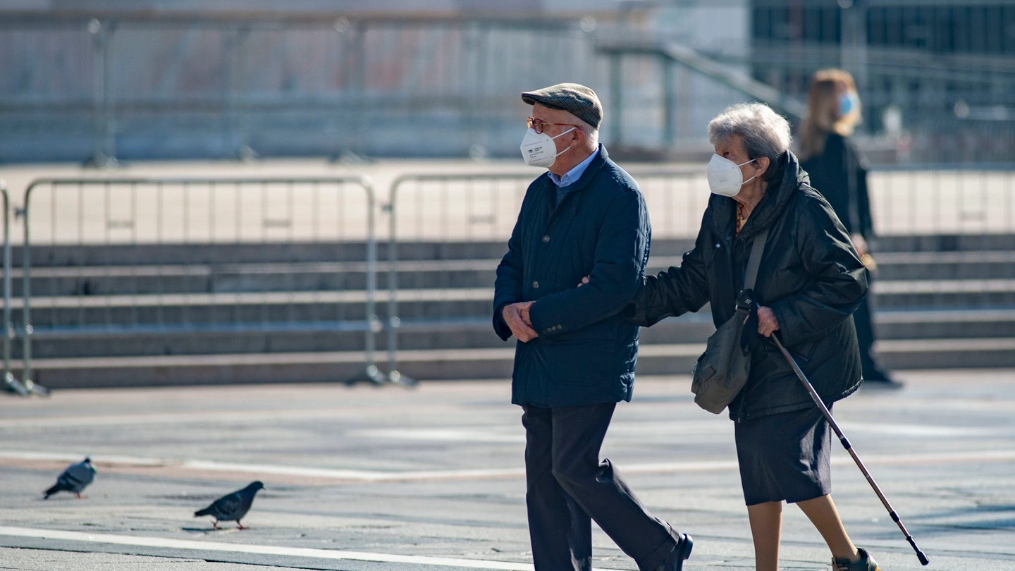 Coppia di anziani passeggia per Milano con la mascherina